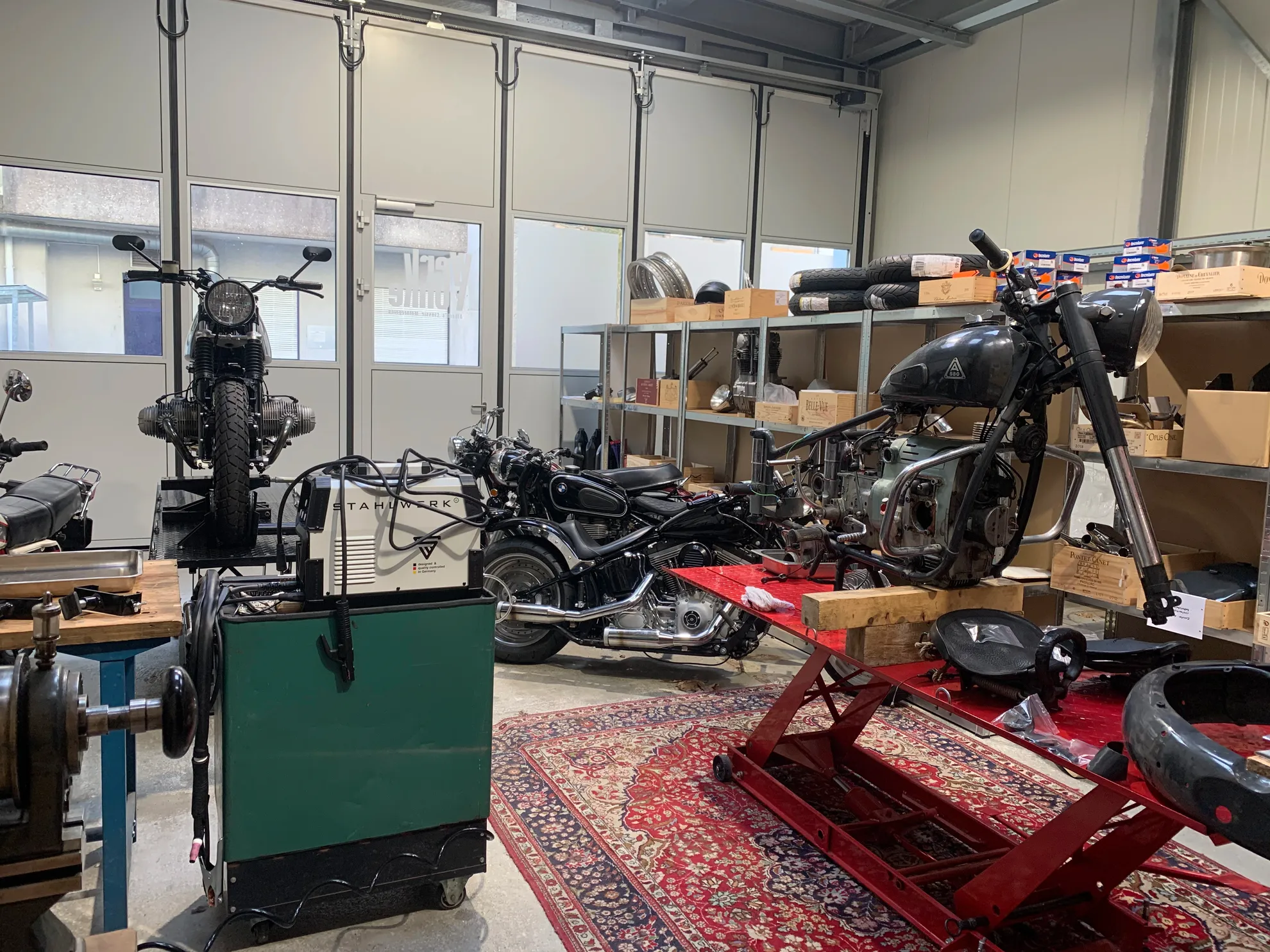 Vue intérieure de l'atelier avec ponts élévateurs et motos anciennes